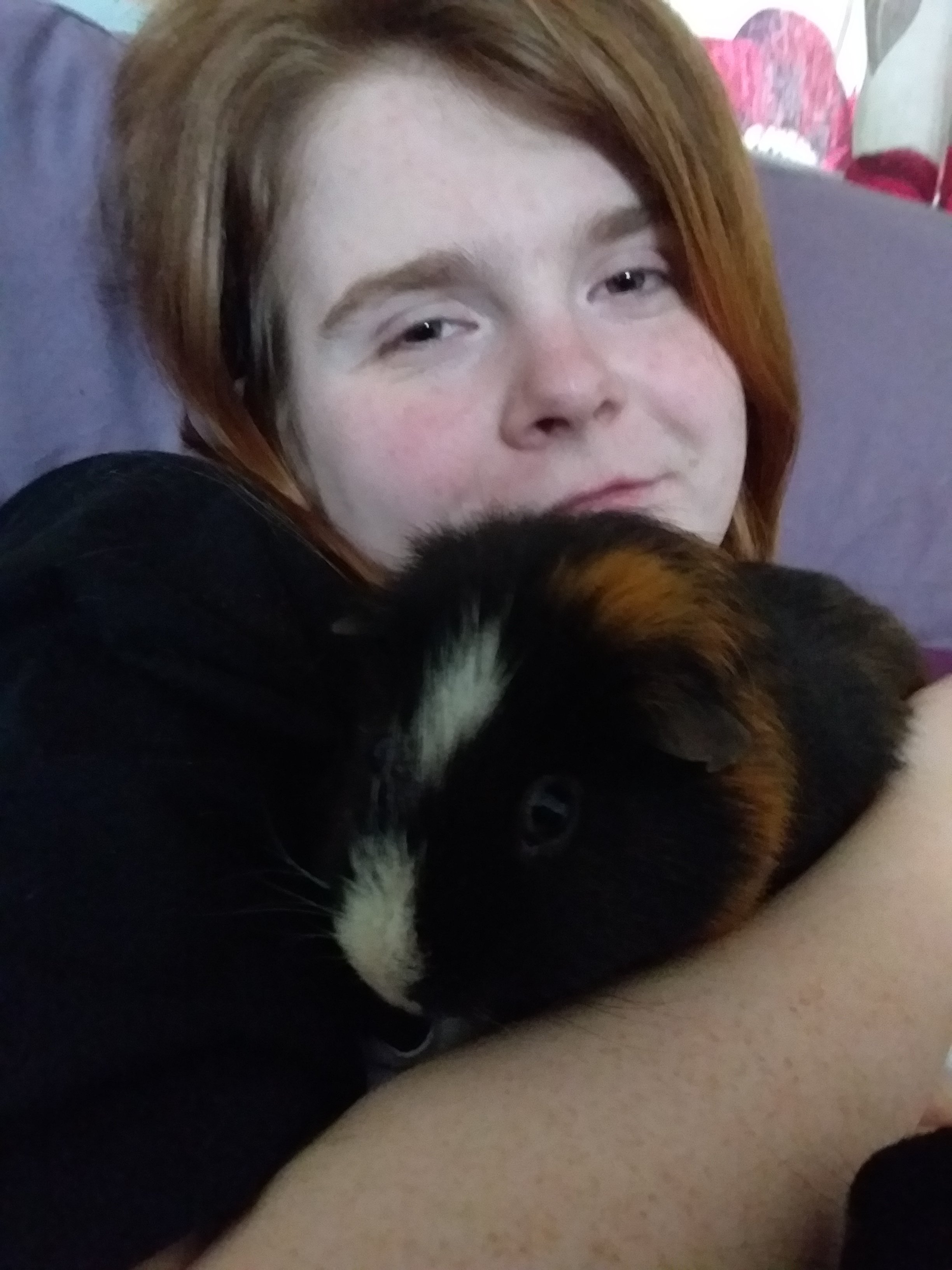 Ami is in bed smiling, holding Loki close to her