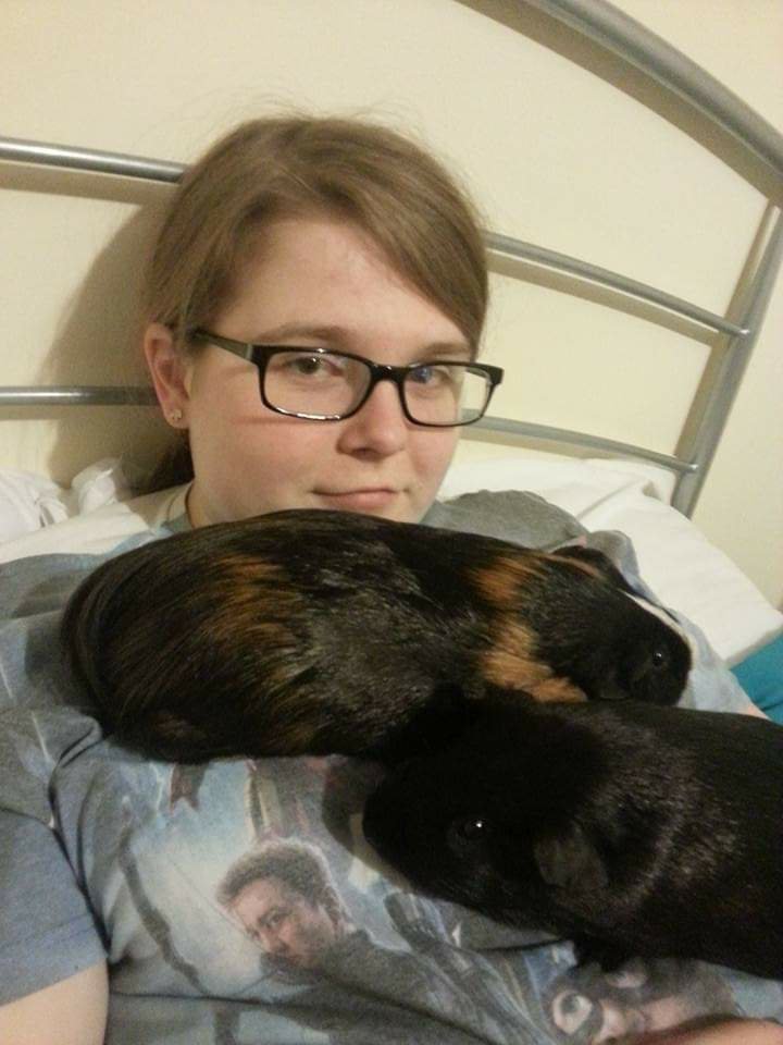 Ami on her bed with Loki and Thor resting on her chest.