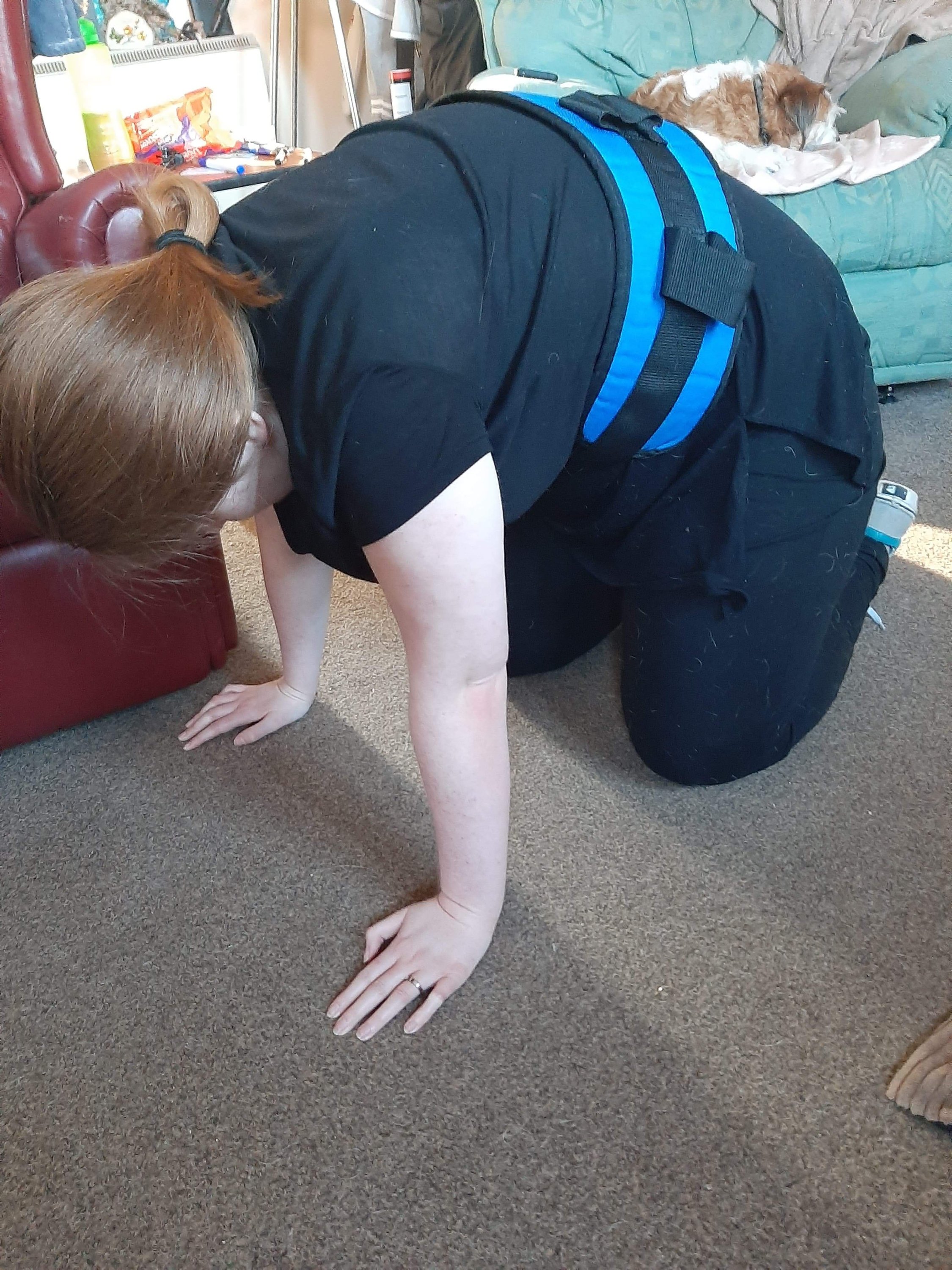 Ami is on the floor, practising getting on her hands and knees