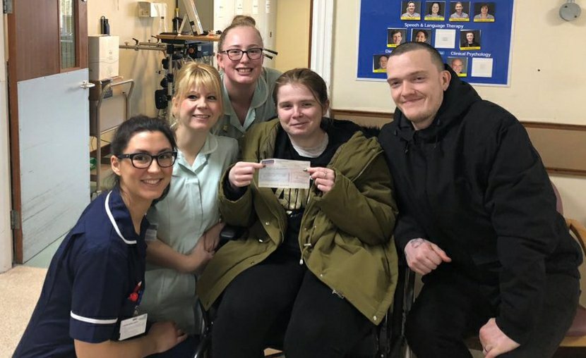 From left to right: West Raynham's ward manager, and 2 healthcare assistants, then Ami and Ewan. We are all smiling as Ami holds a cheque for the physiotherapy department.