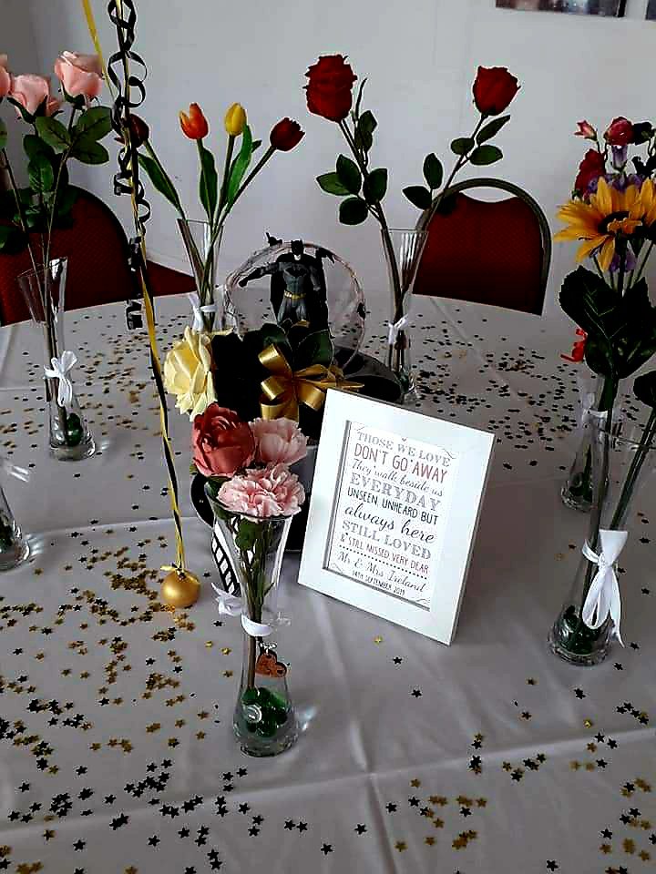 Photo of in memory table, flowers in vases to represent their favourite flowers or colours.
