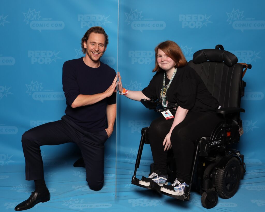 Tom Hiddleston and Ami smiling at the camera.