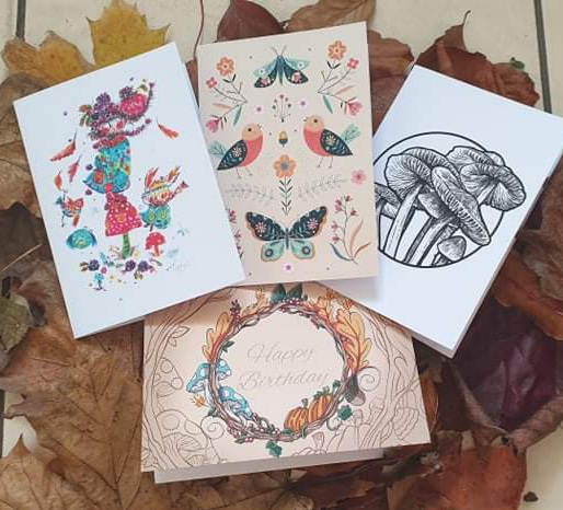 4 autumn themed cards laid on top of leaves