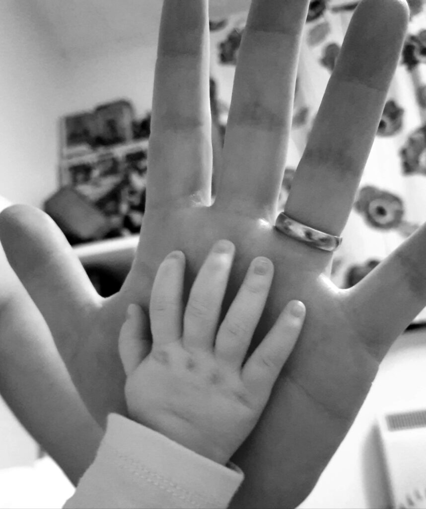 Daisy's hand placed against Daddy's hand