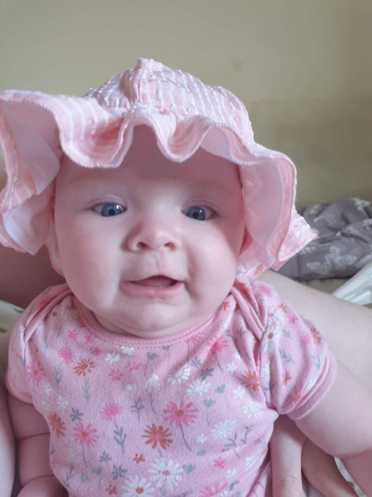 Daisy is wearing a pink summery hat