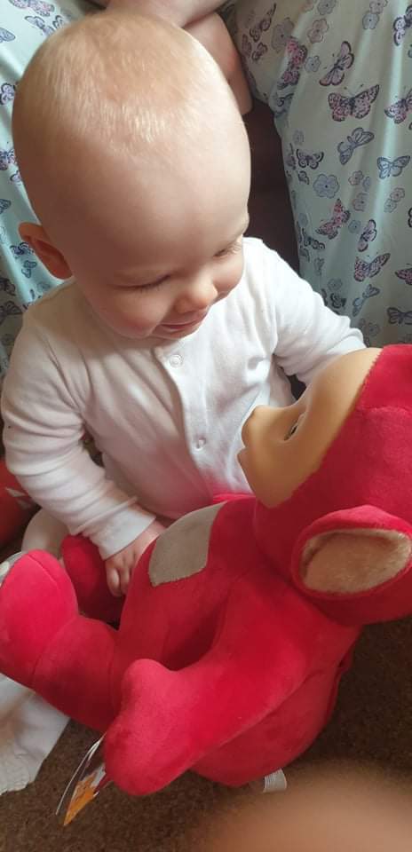 Daisy is holding Po, the red teletubby