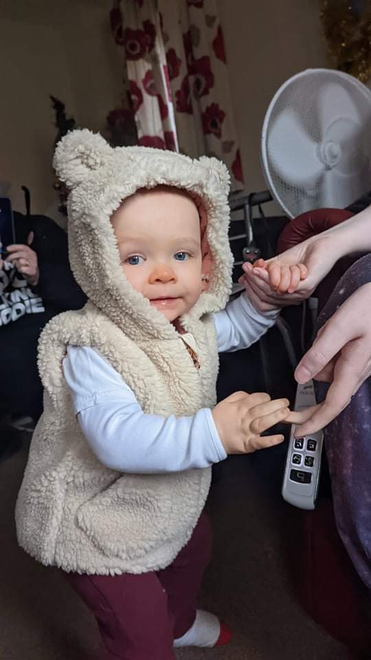Daisy is wearing a beige bear jacket, including little bear ears