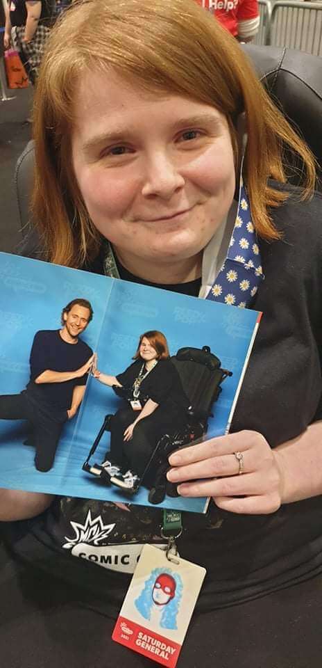 Ami beaming while holding the photo of her and Tom Hiddleston